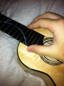 hold (touch your on your ukulele body with right ring and child finger)